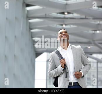 Close up portrait of a happy young man with bag at airport Stock Photo