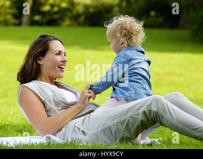 Portrait of a happy mother playing with baby daughter outdoors Stock Photo
