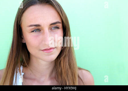 Close up portrait of a beautiful young woman posing against green background Stock Photo