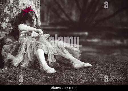 Bored princess; sad and lonely little girl with pink crown Stock Photo