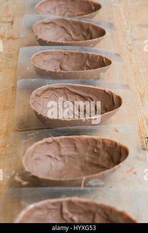Making handmade easter eggs - easter egg moulds with first layer of chocolate Stock Photo