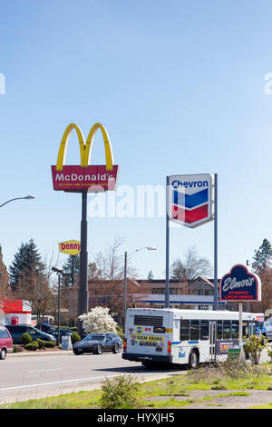 SPRINGFIELD, OR - MARCH 31, 2017: McDonalds and Chevron gas station signs directly next to each other in the Gateway area of Springfield Oregon. Stock Photo