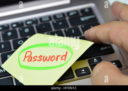 Password written on yellow note on black keyboard Stock Photo