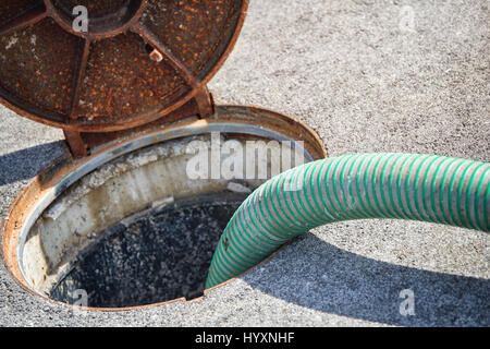 Emptying septic tank, cleaning the sewers Septic cleaning and sewage removal. Emptying household septic tank. Cleaning sludge from septic system. Stock Photo