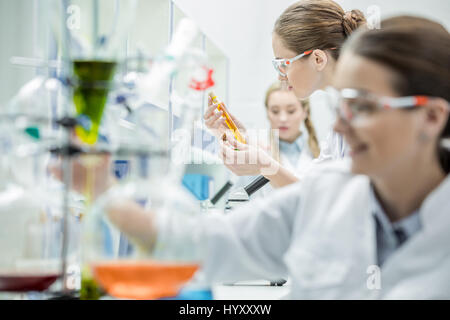 Young female scientists making experiments in chemical laboratory Stock Photo