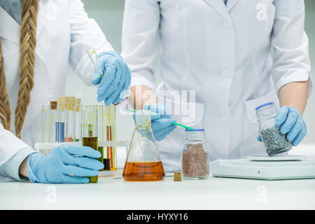 Mid section view of female scientists working in laboratory Stock Photo