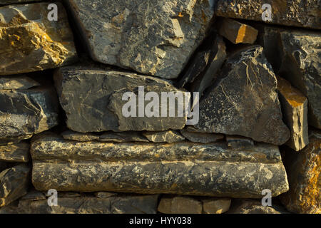 Artistic texture of a rustic vintage brownish stone wall to be used as background Stock Photo