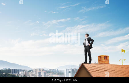 Mister boss on brick roof with arms akimbo. Mixed media Stock Photo