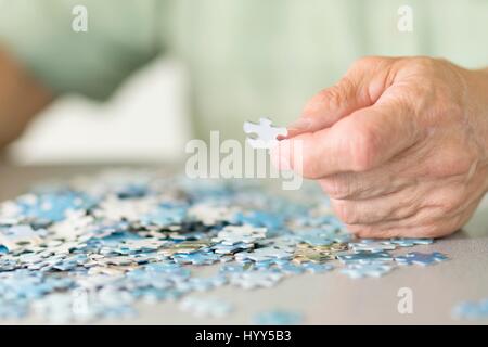 Senior man doing a jigsaw puzzle. Stock Photo