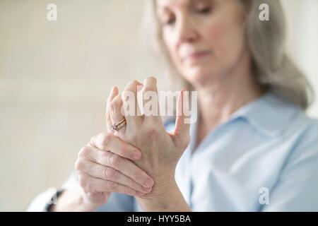 Senior woman holding painful hand. Stock Photo