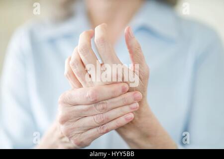 Senior woman holding painful hand. Stock Photo