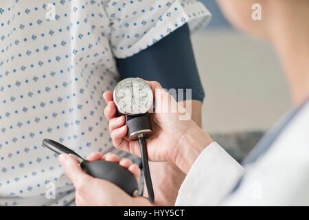 Doctor taking patient's blood pressure. Stock Photo