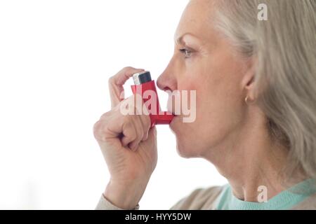 Senior woman using inhaler. Stock Photo