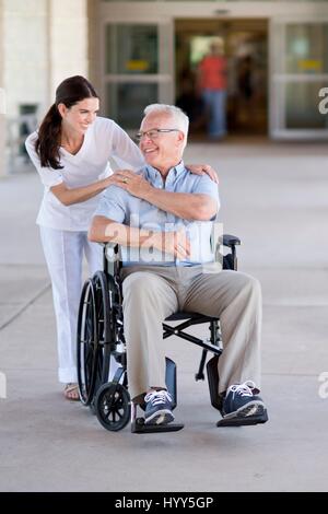 Senior man in wheelchair with care worker. Stock Photo