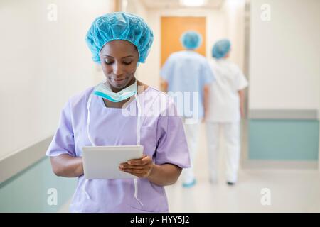 Female surgeon using digital tablet in hospital. Stock Photo