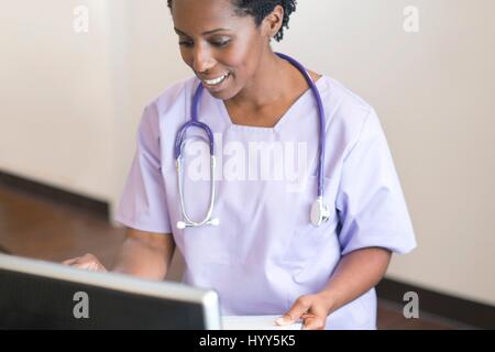 Smiling nurse using computer Stock Photo - Alamy