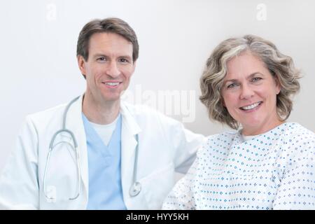 Male doctor and female patient smiling towards camera. Stock Photo