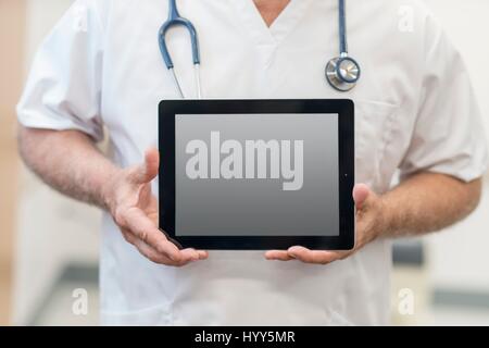 Male doctor holding digital tablet, close up. Stock Photo