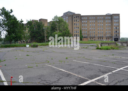 NEW JERSEY, USA: EERIE images and video have revealed the crumbling remains of an abandoned isolation hospital where children were allegedly abused and was the set for the hit Russel Crow movie A Beautiful Mind. The spooky pictures and footage show the contrasting conditions in the left wing and right wing of the old hospital building. The left wing, abandoned since the 1970s, is a flaking, dilapidated mess while the right wing, abandoned in more recent years, looks like it could still be active. Other haunting shots show the rusty padlocked doors, biohazard bags left behind and medical equipm Stock Photo