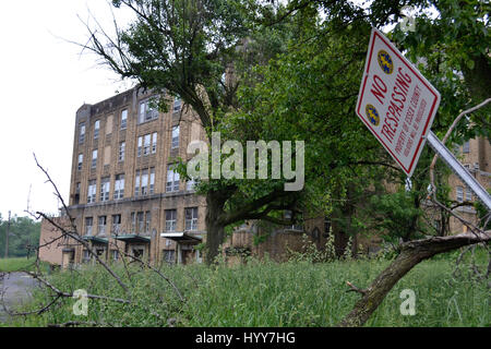 NEW JERSEY, USA: EERIE images and video have revealed the crumbling remains of an abandoned isolation hospital where children were allegedly abused and was the set for the hit Russel Crow movie A Beautiful Mind. The spooky pictures and footage show the contrasting conditions in the left wing and right wing of the old hospital building. The left wing, abandoned since the 1970s, is a flaking, dilapidated mess while the right wing, abandoned in more recent years, looks like it could still be active. Other haunting shots show the rusty padlocked doors, biohazard bags left behind and medical equipm Stock Photo