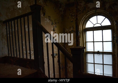 NEW JERSEY, USA: EERIE images and video have revealed the crumbling remains of an abandoned isolation hospital where children were allegedly abused and was the set for the hit Russel Crow movie A Beautiful Mind. The spooky pictures and footage show the contrasting conditions in the left wing and right wing of the old hospital building. The left wing, abandoned since the 1970s, is a flaking, dilapidated mess while the right wing, abandoned in more recent years, looks like it could still be active. Other haunting shots show the rusty padlocked doors, biohazard bags left behind and medical equipm Stock Photo