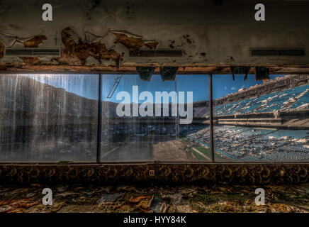 PONTIAC, USA: HAUNTING pictures have revealed the crumbling remains of an 82,000 seat American football stadium that saw its last touchdown long ago. The eerie images show the rows of thousands of blue plastic seats which now lie empty in view of the scorched square of earth where the lush green pitch once was. Other shots of the former Detroit Lions stadium show rubble-strewn remnants of the VIP boxes and forgotten beer bottles and condiments left sitting on a table. The creepy snaps were taken at the Pontiac Silverdome in Pontiac, Michigan by American photographer Jeff Hagerman (36) from Atl Stock Photo