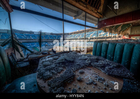 PONTIAC, USA: HAUNTING pictures have revealed the crumbling remains of an 82,000 seat American football stadium that saw its last touchdown long ago. The eerie images show the rows of thousands of blue plastic seats which now lie empty in view of the scorched square of earth where the lush green pitch once was. Other shots of the former Detroit Lions stadium show rubble-strewn remnants of the VIP boxes and forgotten beer bottles and condiments left sitting on a table. The creepy snaps were taken at the Pontiac Silverdome in Pontiac, Michigan by American photographer Jeff Hagerman (36) from Atl Stock Photo