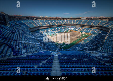 PONTIAC, USA: HAUNTING pictures have revealed the crumbling remains of an 82,000 seat American football stadium that saw its last touchdown long ago. The eerie images show the rows of thousands of blue plastic seats which now lie empty in view of the scorched square of earth where the lush green pitch once was. Other shots of the former Detroit Lions stadium show rubble-strewn remnants of the VIP boxes and forgotten beer bottles and condiments left sitting on a table. The creepy snaps were taken at the Pontiac Silverdome in Pontiac, Michigan by American photographer Jeff Hagerman (36) from Atl Stock Photo
