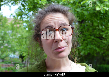 Portrait of young nerd woman with big dioptric dusty glasses Stock Photo