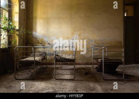 HAUNTING images have revealed what could be the spookiest abandoned bedrooms in the world. The stunning series of images show sterile rows of unmade beds in a former children’s hospital in Italy, a lone mattress on the cold brick floor of a long-forgotten building and a regal looking bedroom complete with ornate headboard which takes pride of place in the centre of a French castle’s bedroom. Other chilling snaps illustrate how nature has taken over these rooms with mould covered walls and rotting mattresses. One image even shows how a wooden bedframe has completely collapsed and another shows  Stock Photo