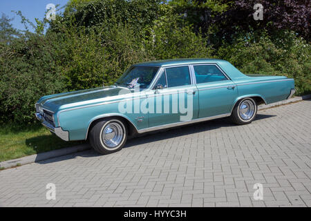 ROSMALEN, THE NETHERLANDS - MAY 8, 2016: Side view of a parked 1964 Oldsmobile F-85 classic car. Stock Photo