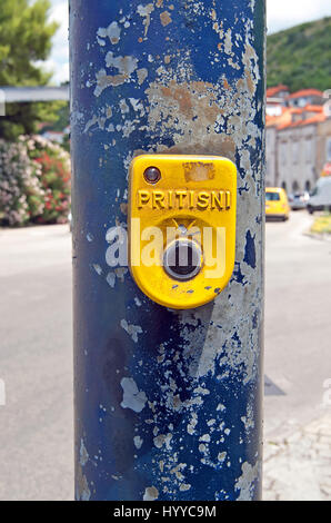 Crosswalk button with a blurred road in the background Stock Photo