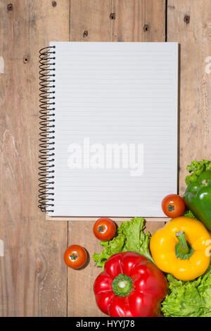 Notebook for culinary recipes with fresh organic vegetables Stock Photo