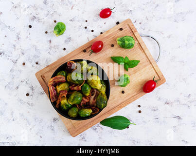 Roasted brussels sprouts with bacon on white background. Top view Stock Photo