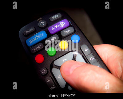 Thumb pressing OK button on BT youview remote control Stock Photo