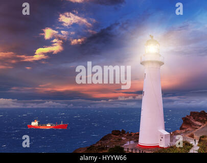Sunset seascape, lighthouse on the bluff Stock Photo