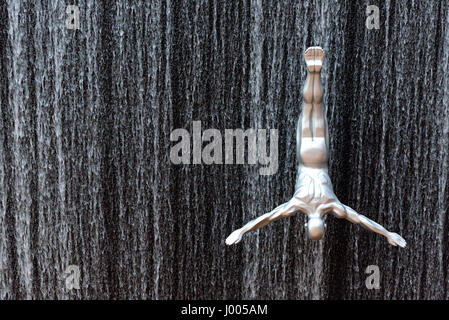 silver male sculpture installed to create a jumping effect on the fountain of Dubai Mall in Dubai, United Arab Emirates. Stock Photo