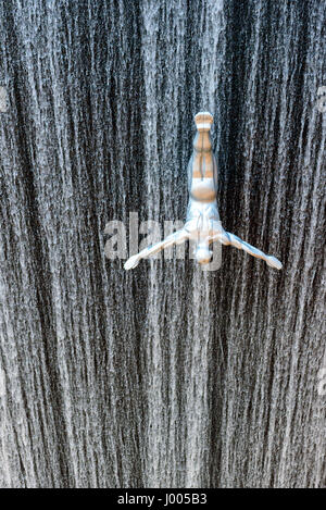 silver male sculpture installed to create a jumping effect on the fountain of Dubai Mall in Dubai, United Arab Emirates. Stock Photo