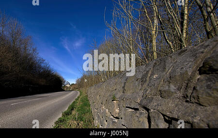 Rural road and stone wall.Peak District National Park,Derbyshire countryside landscape in springtime,Derbyshire,Uk.Peak District landscape in spring. Stock Photo