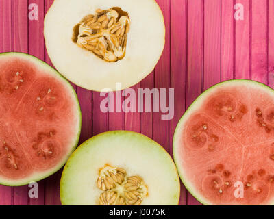 Water Melon Galia Melon and Honeydew Melon Against a Pink Background