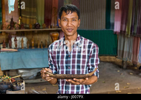 Siem Reap, Cambodia - January 03, 2017: An artisan at the palm sugar producers village showing one of his wooden work Stock Photo