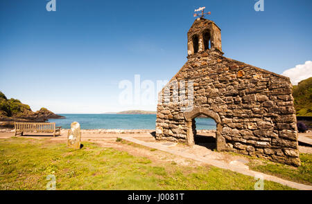 The ruined gable end wall of the chapel beside the sea at Newport Bay and Dinas Island in the Pembrokeshire Coast National Park, Wales. Stock Photo