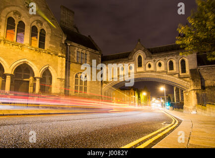 Traffic rushes down Winetavern Street in Dublin at night, under the enclosed stone arch bridge that links Christ Church Cathedral with the Synod Hall. Stock Photo
