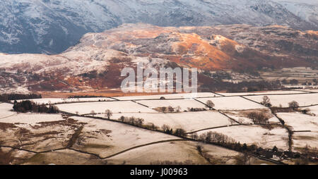Winter snow lies on fields and mountains around Castlerigg stone circle in England's lake district. Stock Photo