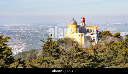 The cliche view of the fairytale Palacio da Pena royal palace from the High Cross on the mountaintop at Sintra near Lisbon in Portugal. Stock Photo