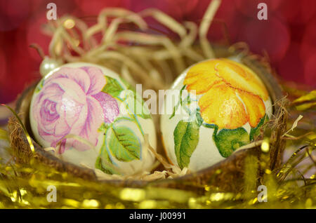 Easter egg decorated with flowers made by decoupage technique on bokeh background Stock Photo