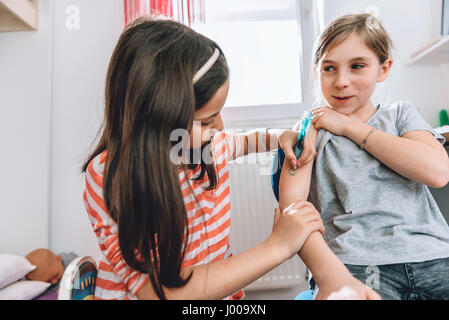 Girl writing tattoo on arm of her girlfriend with pen Stock Photo