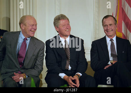 U.S President Bill Clinton shares a laugh with former Presidents George H.W. Bush, right, and Gerald Ford, left, at kick off ceremony for NAFTA in the East Room of the White House September 14, 1993 in Washington, DC. The North American Free Trade Agreement was proposed by President Ford, negotiations began under President Bush and were finalized by President Clinton. Stock Photo