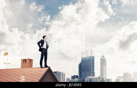 Mister boss on brick roof with arms akimbo. Mixed media Stock Photo