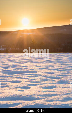 Sun Setting Over Beautiful Snowy Field Stock Photo